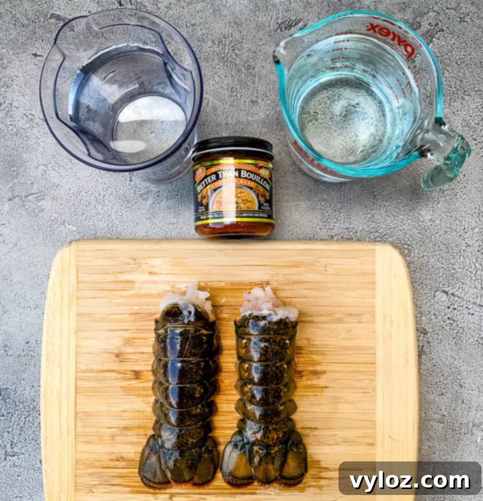 Two perfectly cooked lobster tails, one whole and one with its rich, white meat exposed, ready for the creamy bisque, showcasing the quality of ingredients.