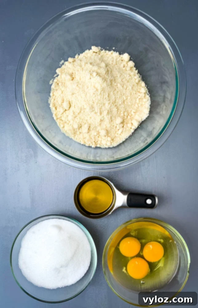 Almond flour, sweetener, eggs, and olive oil in separate bowls for keto zucchini bread preparation