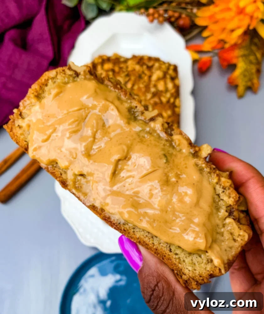 Person holding a slice of keto zucchini bread with almond butter