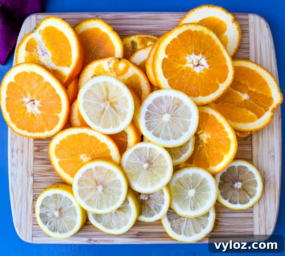 Sliced lemons and oranges on a cutting board, ready for a refreshing drink