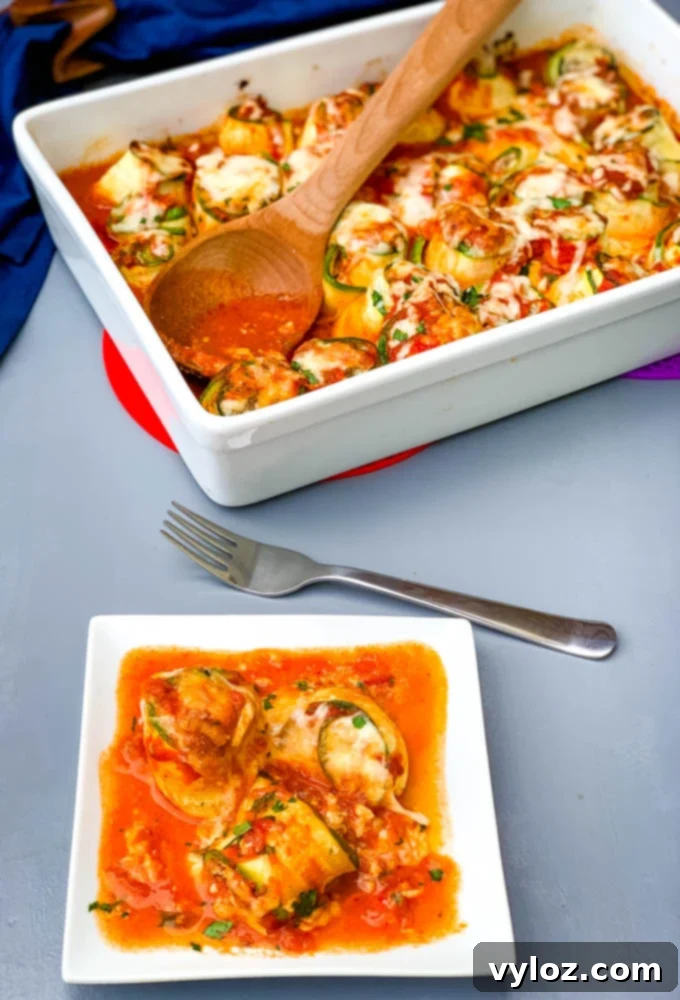 Quick Zucchini Lasagna Pinwheels 12 A white baking pan filled with zucchini lasagna roll ups, served alongside a plate with a few rolls garnished with fresh herbs, showcasing a ready meal.