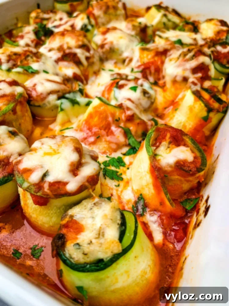 Quick Zucchini Lasagna Pinwheels 13 A large white baking pan filled with golden, cheesy zucchini lasagna roll ups, ready to be served.