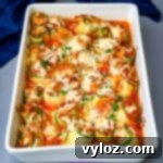 Quick Zucchini Lasagna Pinwheels 14 zucchini lasagna roll ups in a white baking pan with shredded cheese