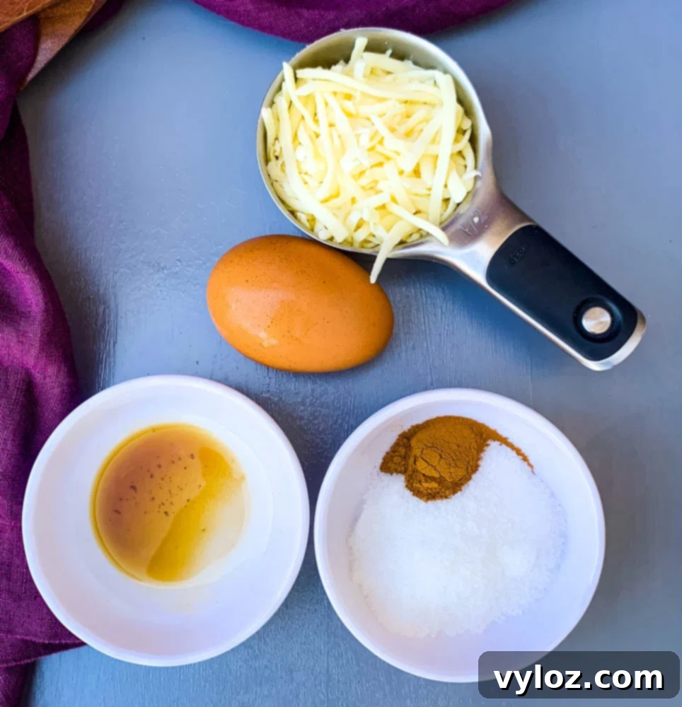 Shredded mozzarella cheese, egg, vanilla extract, and sweetener laid out as ingredients for keto low carb chaffles.