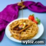 keto low carb chaffles on a white plate with butter and syrup