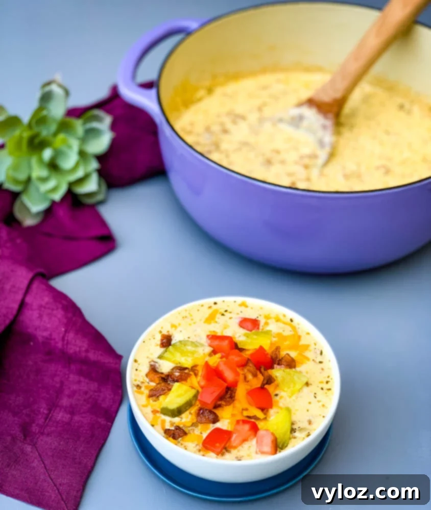 Savory Keto Cheeseburger Bliss 9 A beautifully presented bowl of keto low carb cheeseburger soup, generously topped with crispy bacon, tangy pickles, and fresh tomatoes.