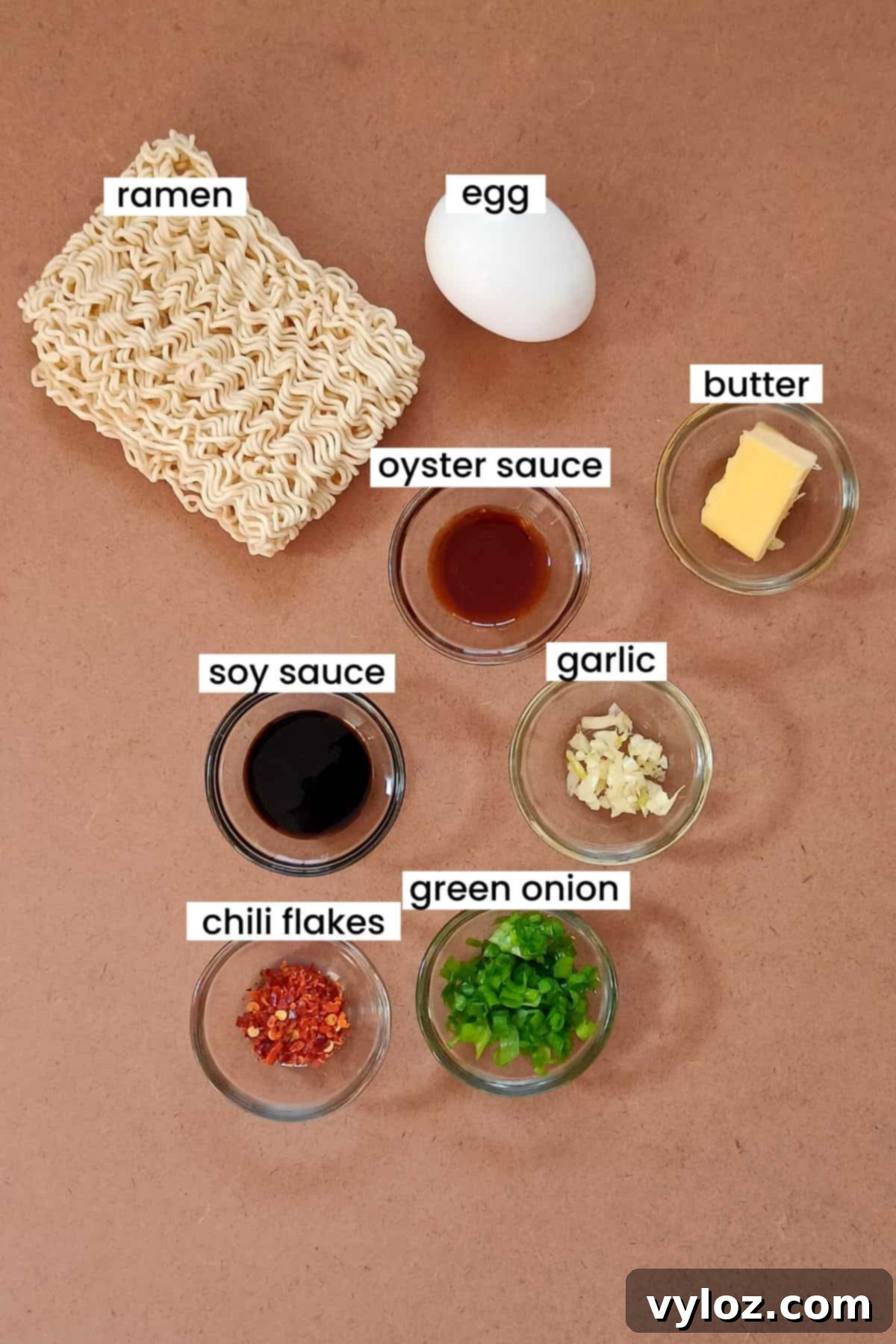 Essential ingredients for ramen scrambled eggs, meticulously arranged on an earthy-toned surface, highlighting freshness and quality.