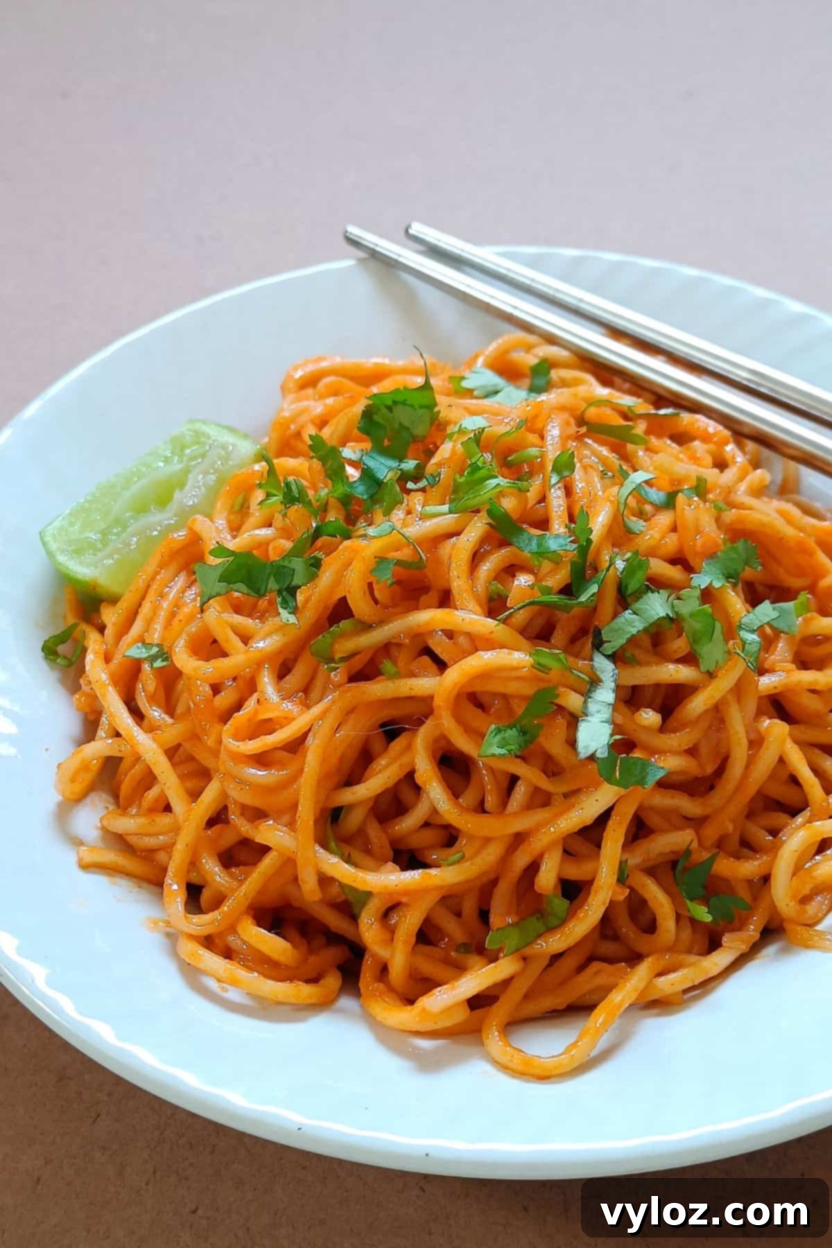 Gochujang butter noodles served on a white plate, garnished with fresh cilantro.