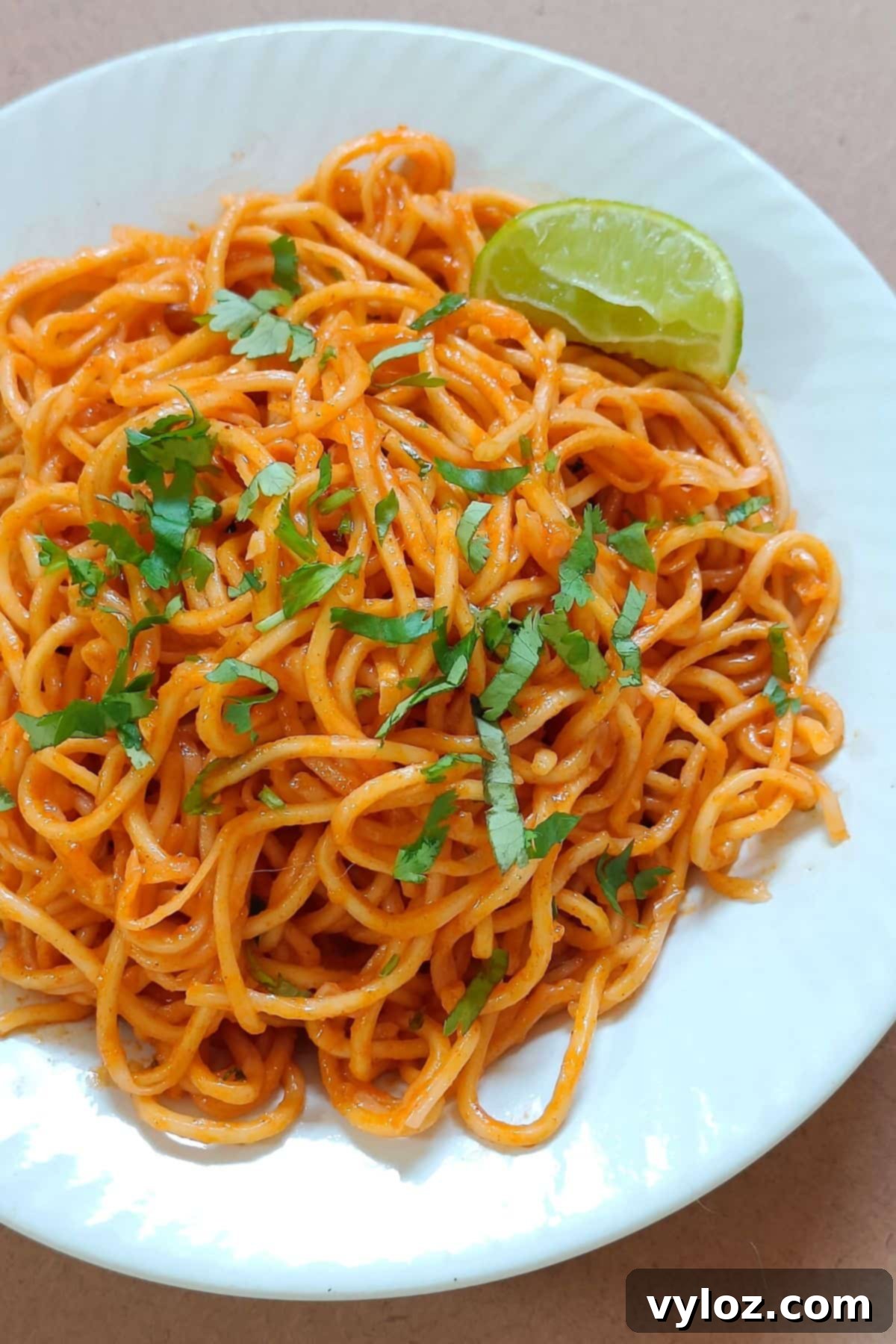 Gochujang butter noodles served on a white plate, garnished with fresh cilantro and sesame seeds.