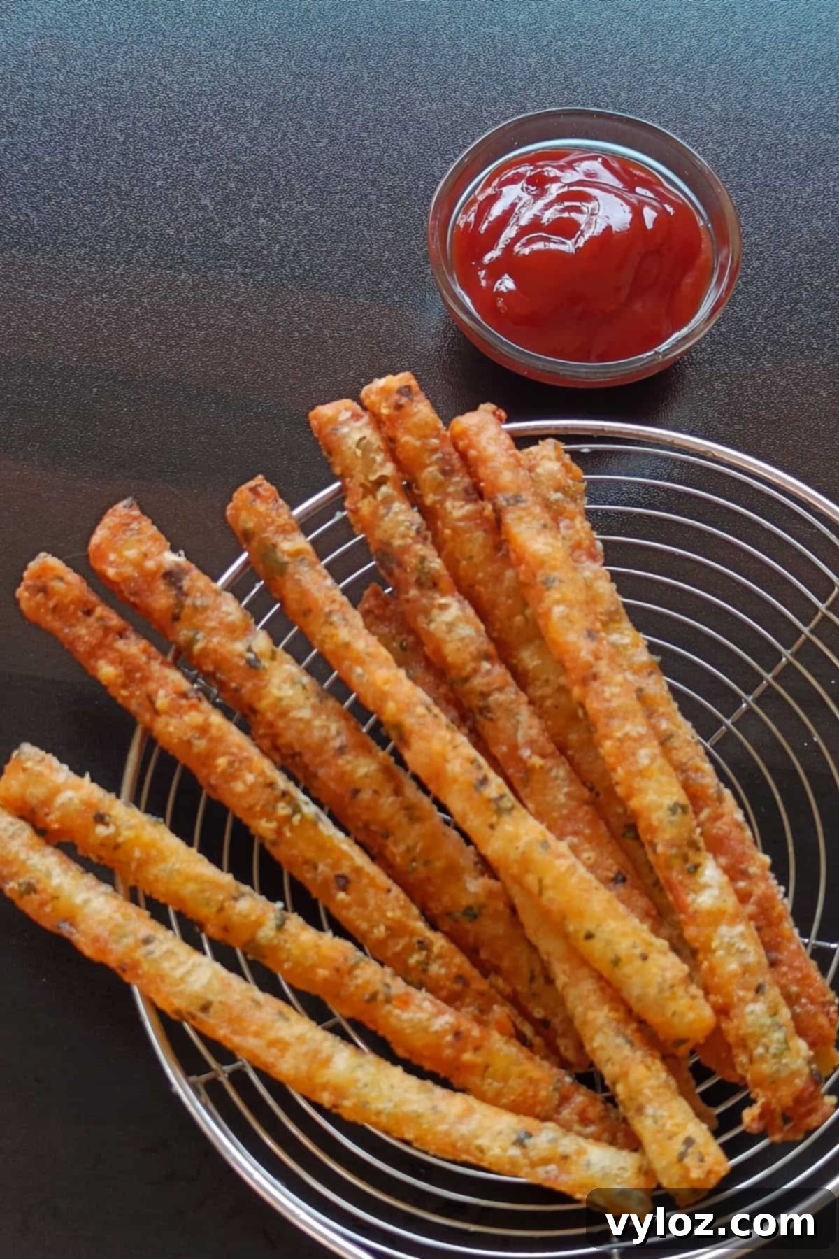 Long mashed potato fries served with tomato ketchup, showcasing their golden-brown crisp exterior.