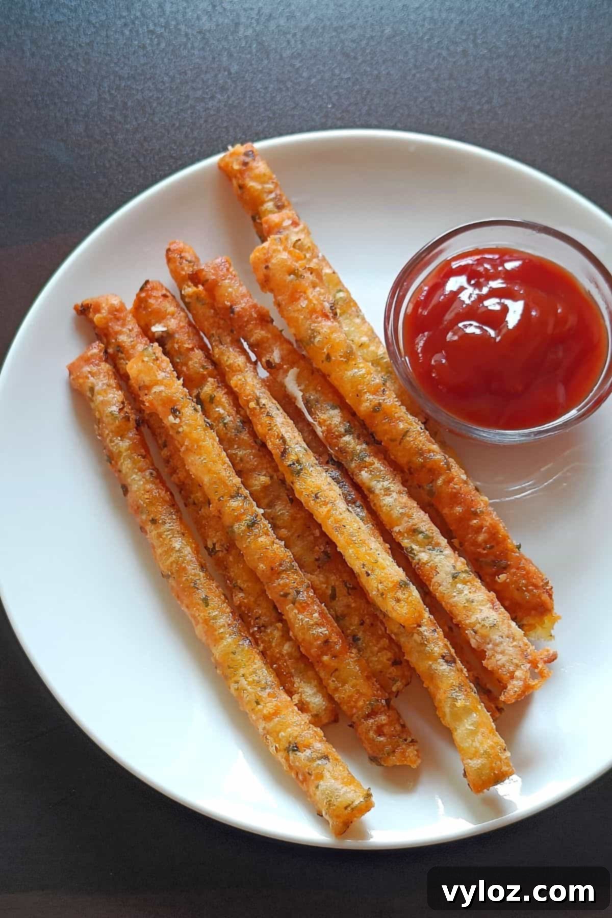 A close-up image of crispy mashed potato sticks beautifully arranged on a white plate, ready to be served.