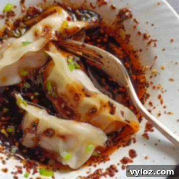 The Ultimate Wet Sauce 7 Dumplings are served over wet wet sauce in a white bowl.