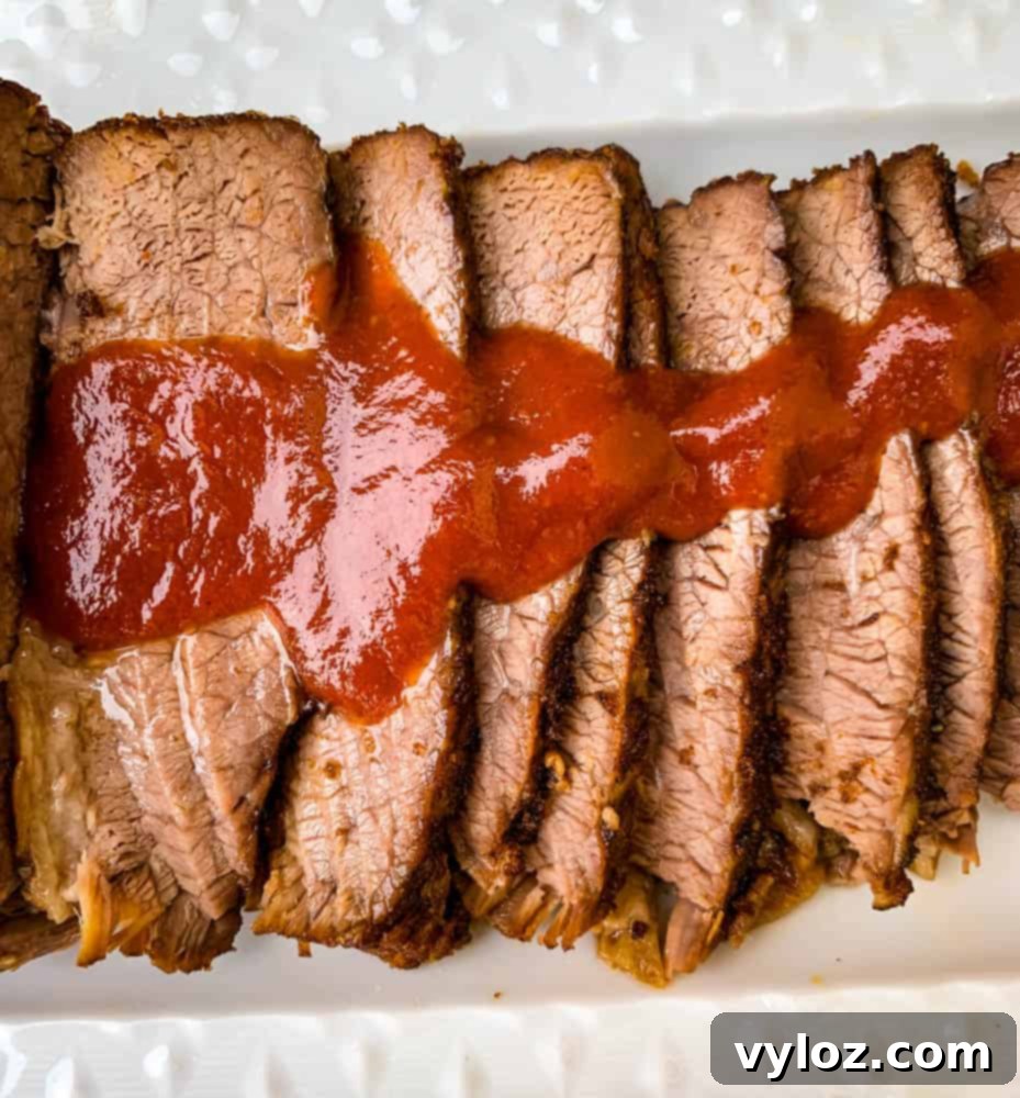 Tender Instant Pot Brisket 9 Instant Pot Beef Brisket with BBQ Sauce on a white plate