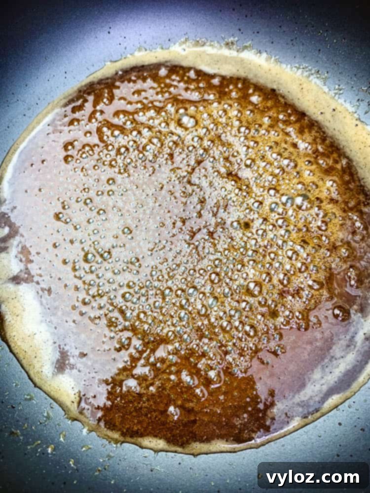 Honey, ground cloves, and brown sugar are artfully presented in a saucepan, ready to be transformed into the luscious glaze for an air fryer honey glazed ham.