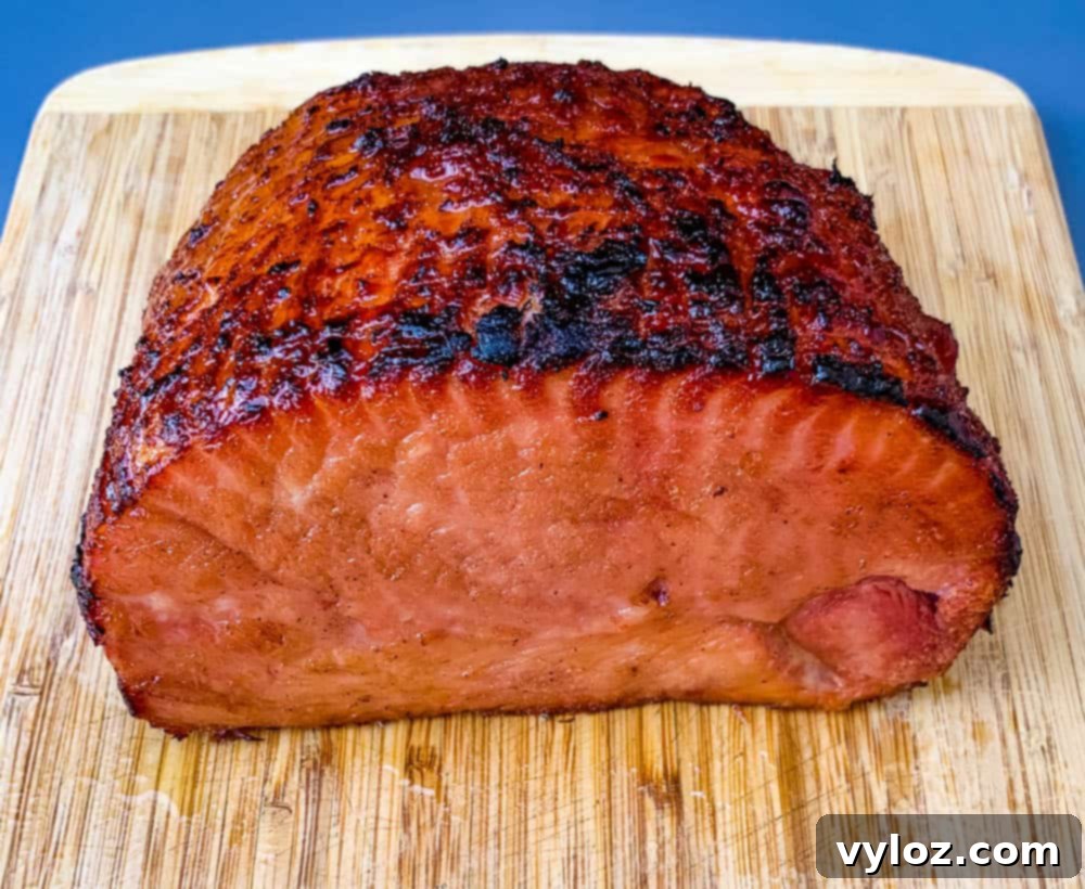 A boneless ham rests on a sturdy cutting board, perfectly prepared for glazing and ready to be cooked to perfection in an air fryer.