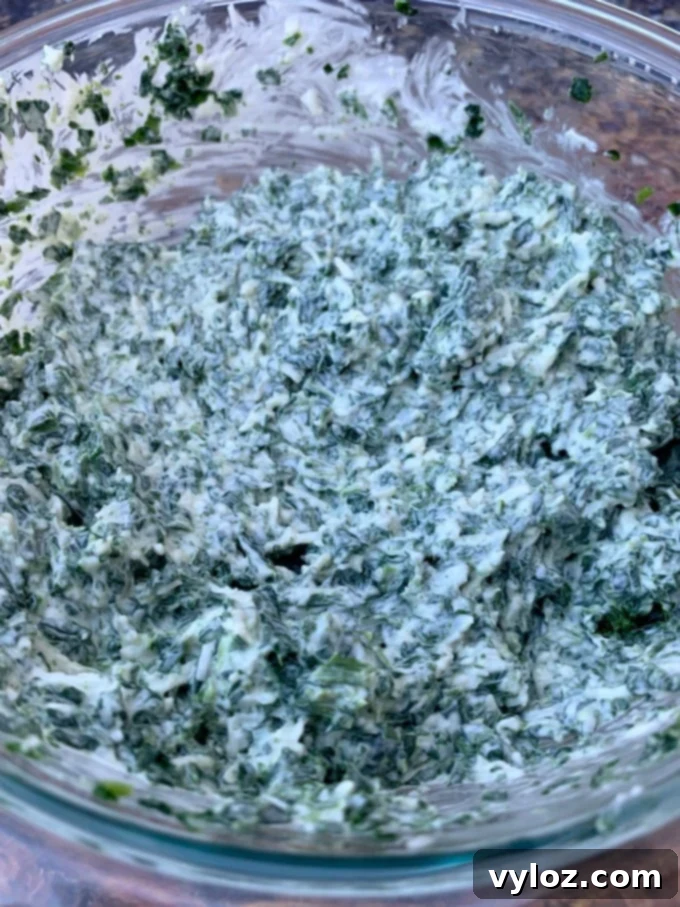Warm Baked Spinach and Cheese Dip 5 Top-down view of a glass bowl filled with rich, keto low carb spinach dip, ready for serving