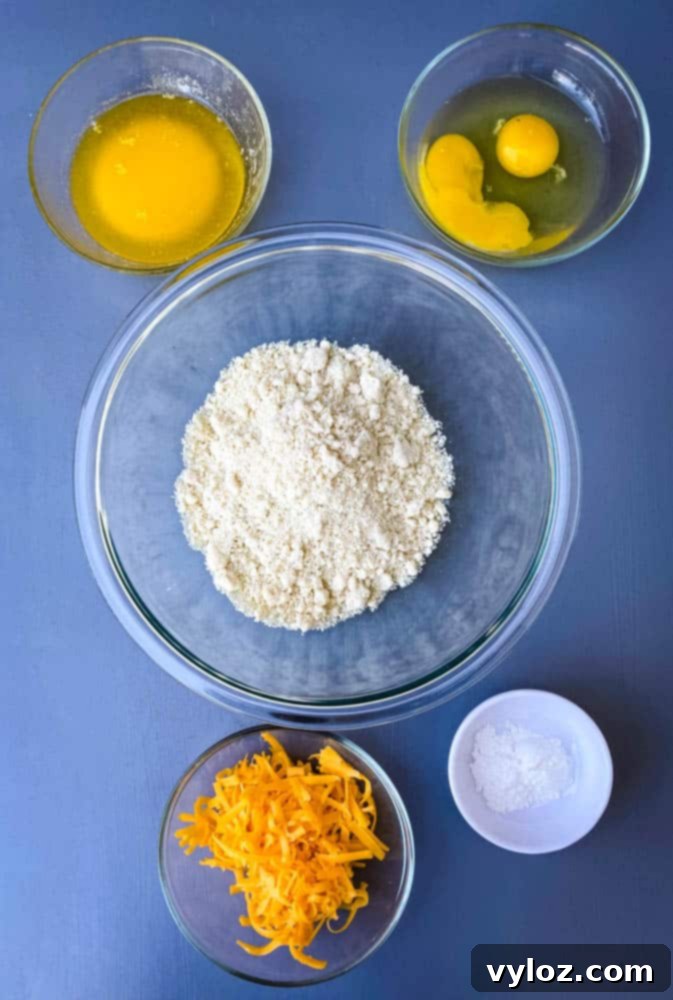 Ingredients for keto low carb chicken pot pie crust: almond flour, eggs, melted butter, shredded cheese, and baking powder