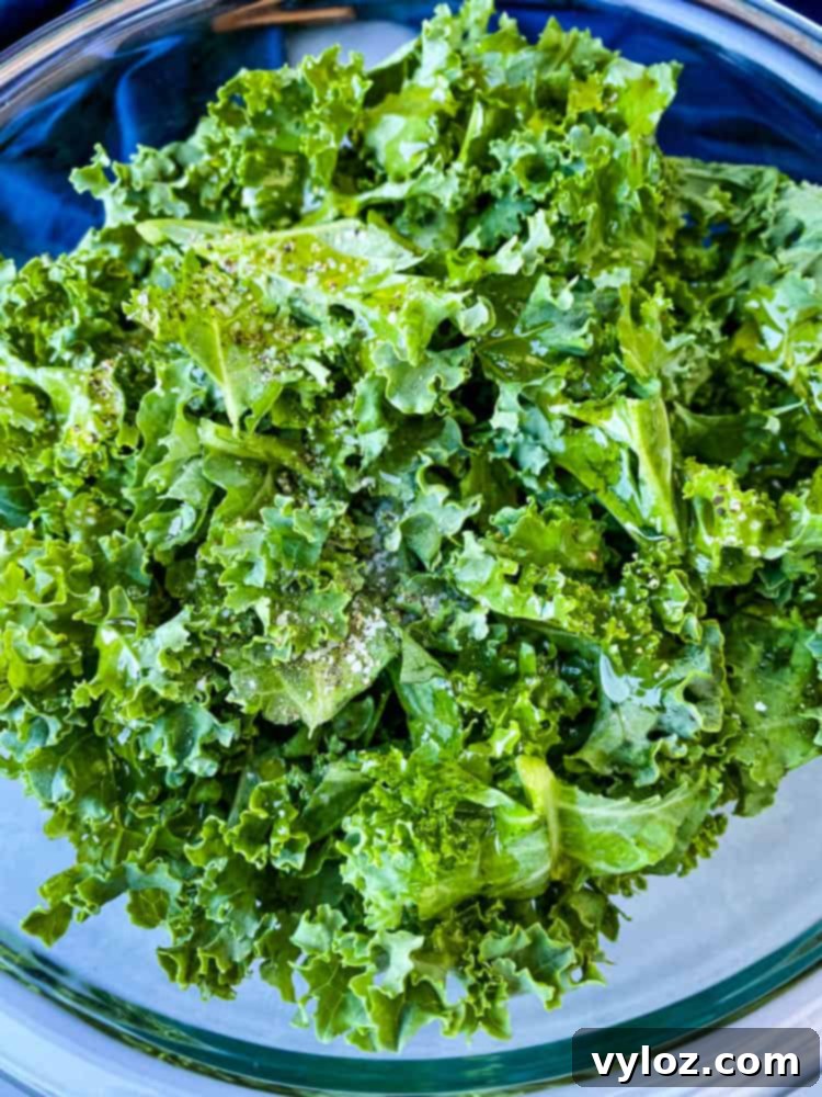 Fresh raw kale leaves in a glass bowl, perfectly prepped for making healthy air fryer kale chips