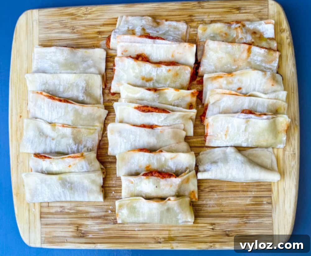 pizza rolls in wonton wrappers on a bamboo cutting board