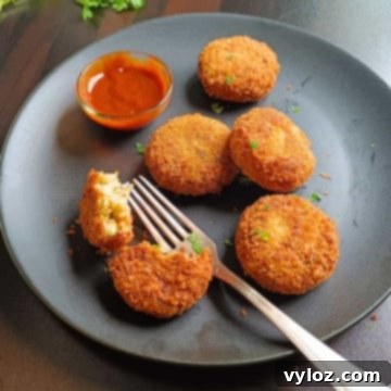 Image showing crispy cutlets in a black platter, garnished with fresh herbs.