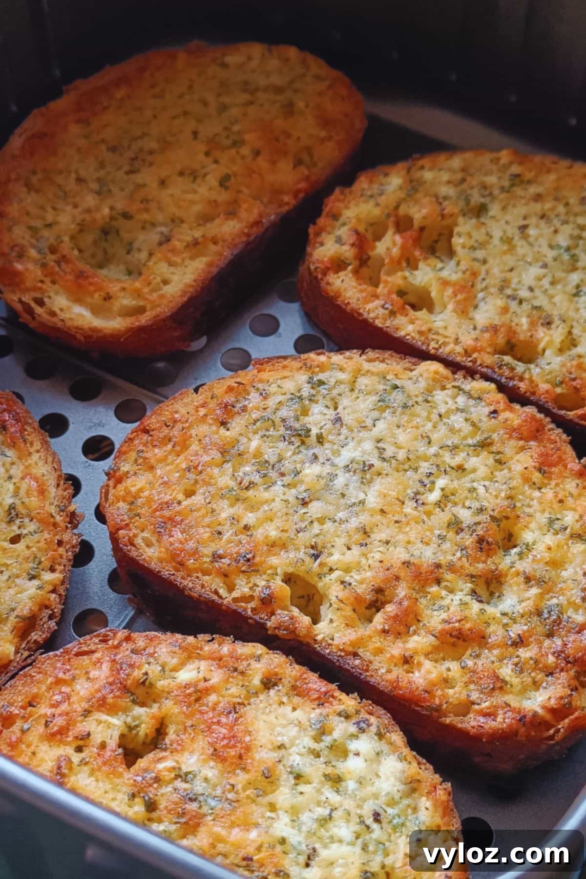 Golden brown garlic bread slices perfectly air-fried, arranged on a serving board.