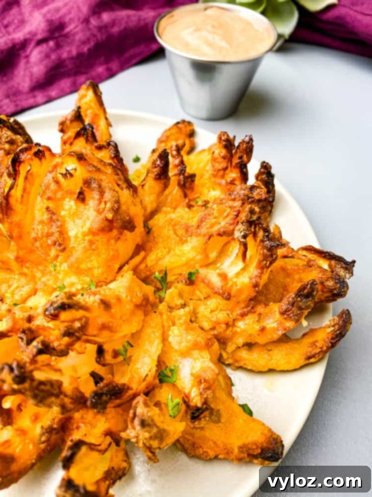 Restaurant-Style Air Fryer Blooming Onion 11 A beautifully presented Air Fryer Blooming Onion on a plate, garnished with fresh lemon slices.