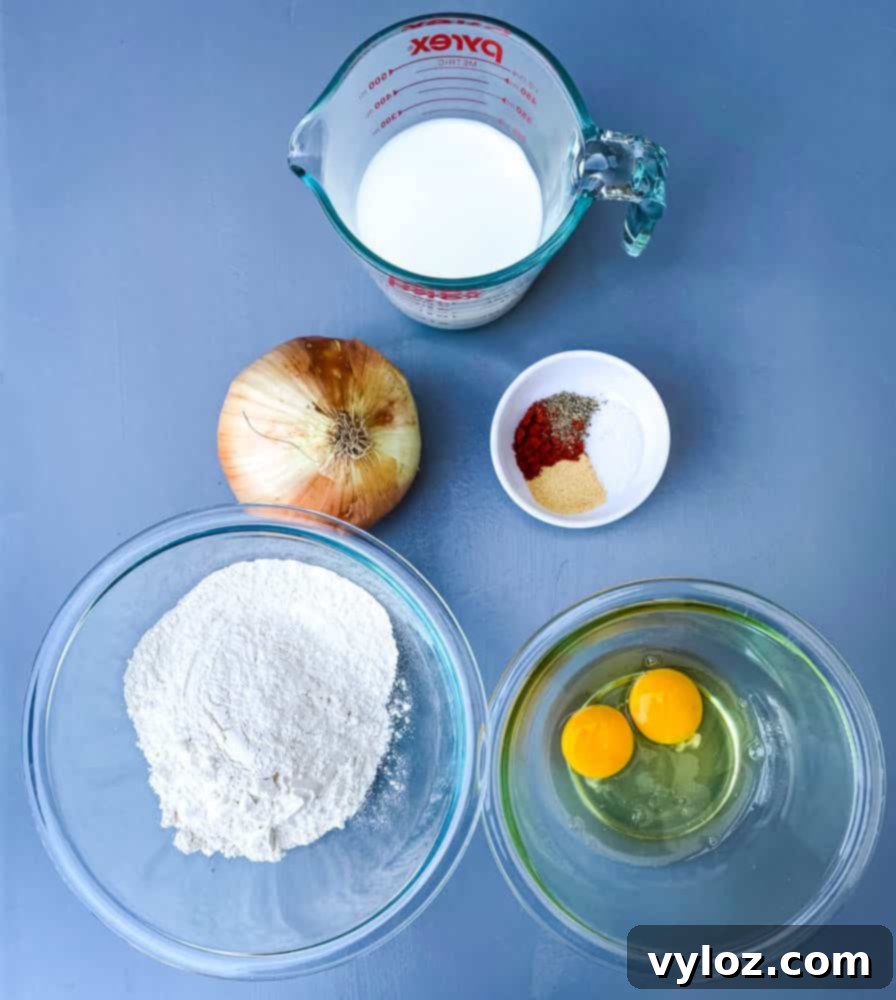 Restaurant-Style Air Fryer Blooming Onion 3 Milk, flour, egg, and seasoning ingredients laid out for making the Air Fryer Blooming Onion batter.