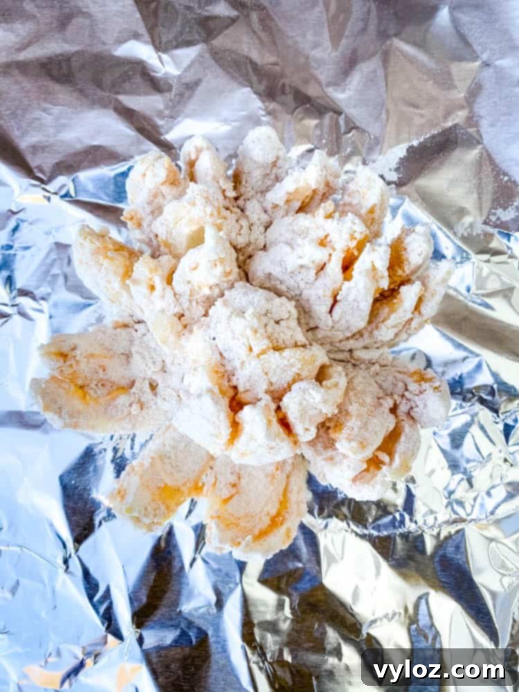 Restaurant-Style Air Fryer Blooming Onion 5 Air fryer blooming onion wrapped in aluminum foil, ready for freezing.