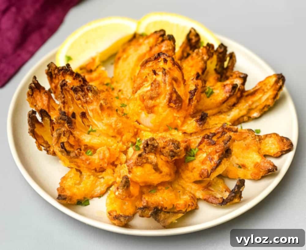 Restaurant-Style Air Fryer Blooming Onion 10 A freshly made Air Fryer Blooming Onion on a plate, garnished with lemon slices, and ready to serve.