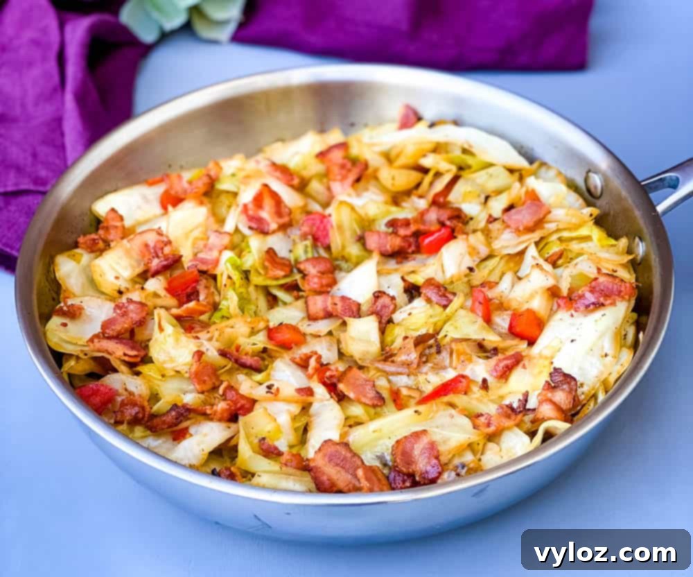 Southern fried cabbage with crispy bacon in a shining stainless steel pan, ready to serve.
