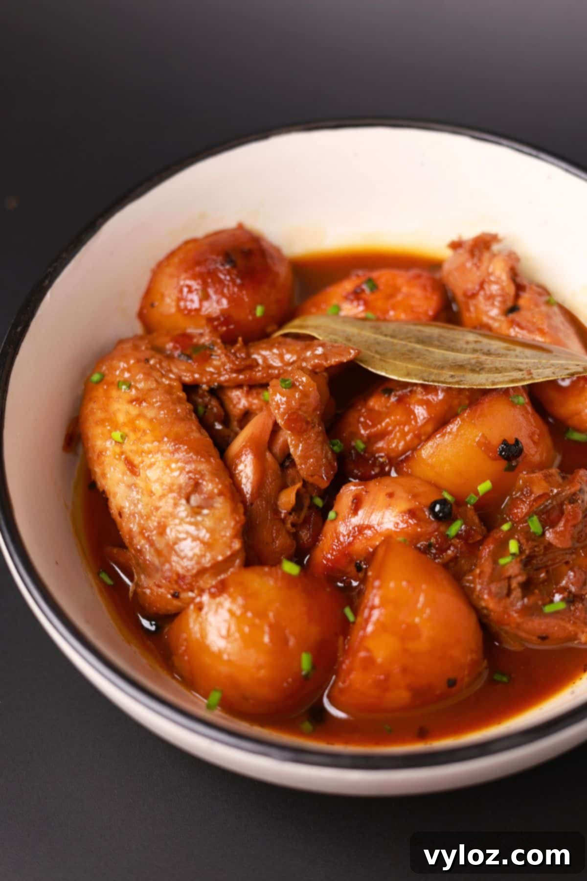 A beautifully plated serving of Filipino Chicken Adobo with Potatoes in a white bowl, ready to be enjoyed.