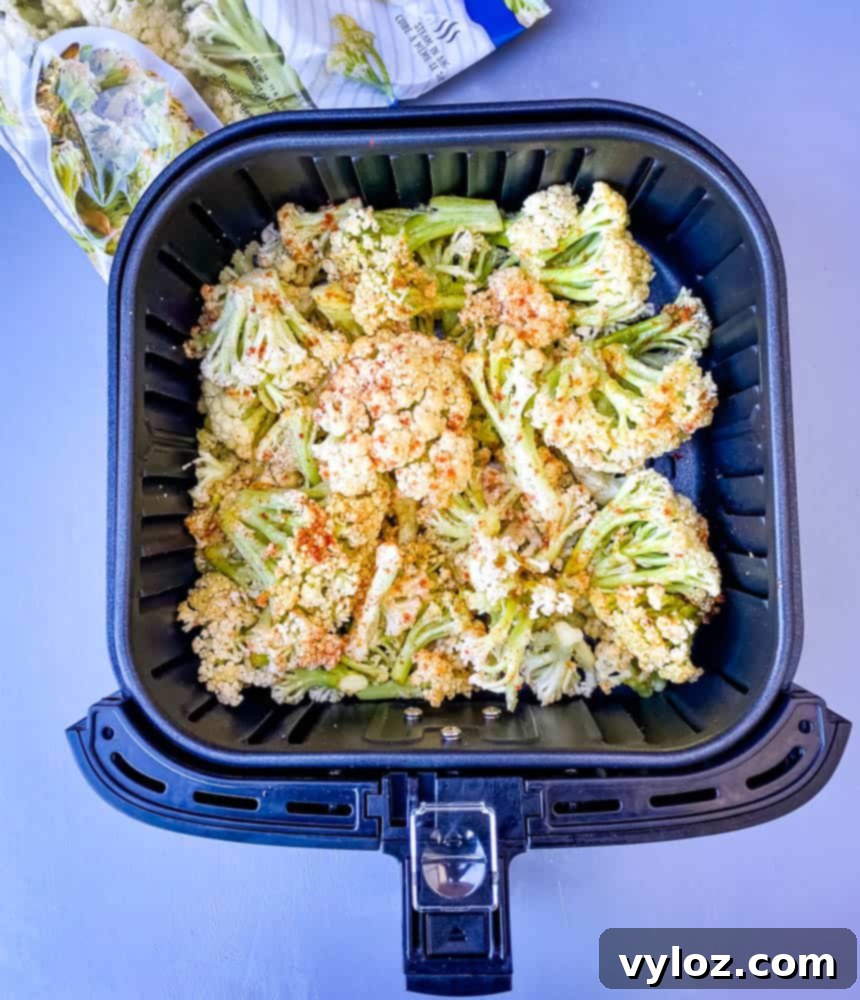 caulilini being cooked in an air fryer basket