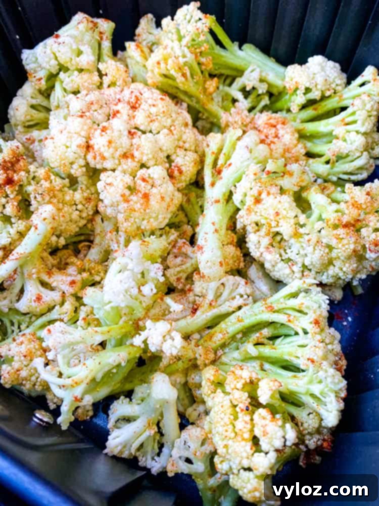 caulilini with melted parmesan cheese in an air fryer basket