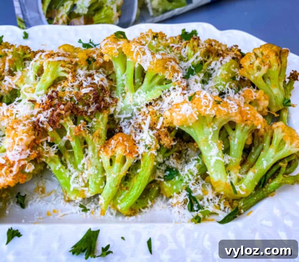 air fryer caulilini on a white plate with fresh herbs