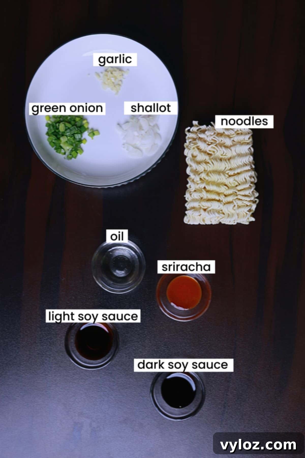 Ingredients for indomie noodles recipe are arranged on a brown backdrop.