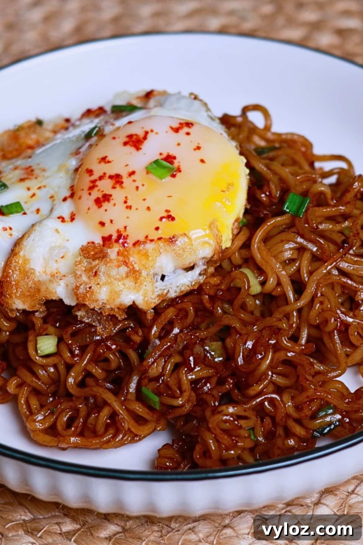 Indomie noodles served with egg, garnished with green onion.