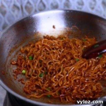 Indomie noodles in a stainless steel pan.