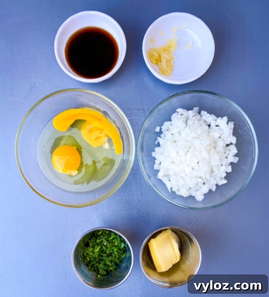 Fresh ingredients for air fryer meatloaf: chopped onions, eggs, parsley, and butter.