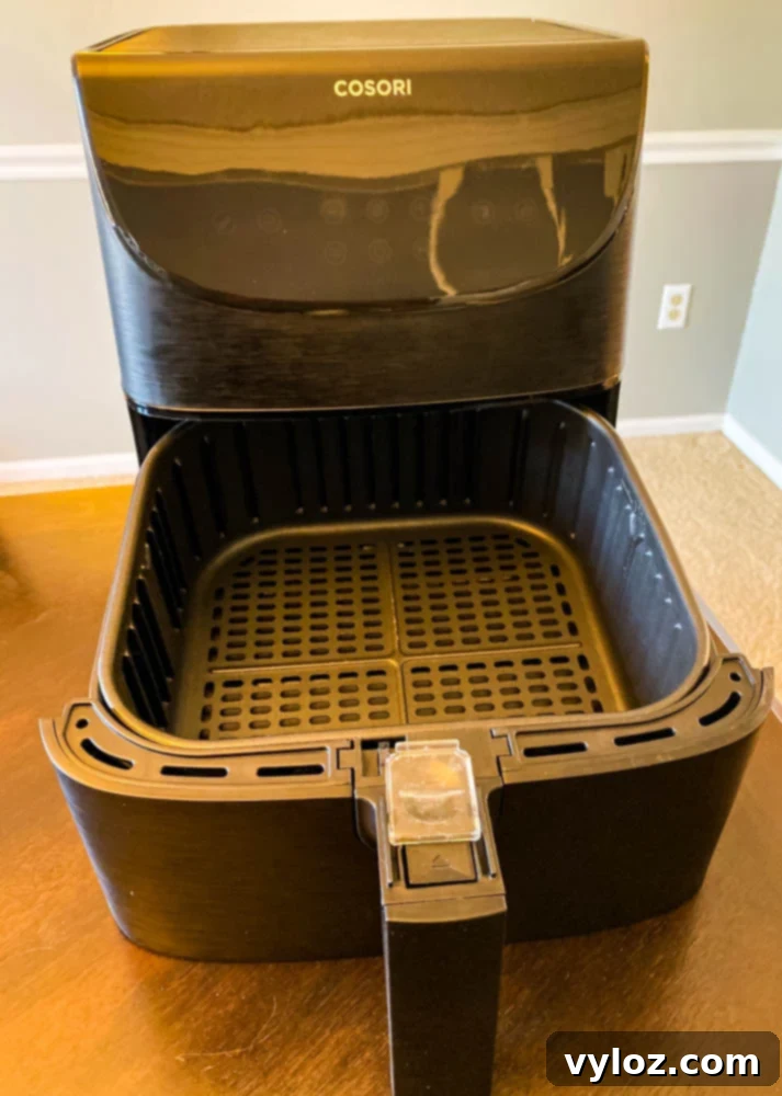 Cosori 5.8-quart air fryer with its basket pulled out, ready to cook.