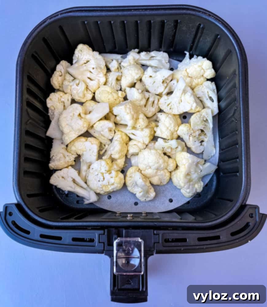 raw cauliflower in an air fryer basket