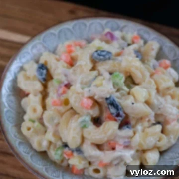 Filipino chicken macaroni salad served in a bowl with creamy dressing and colorful mix-ins.