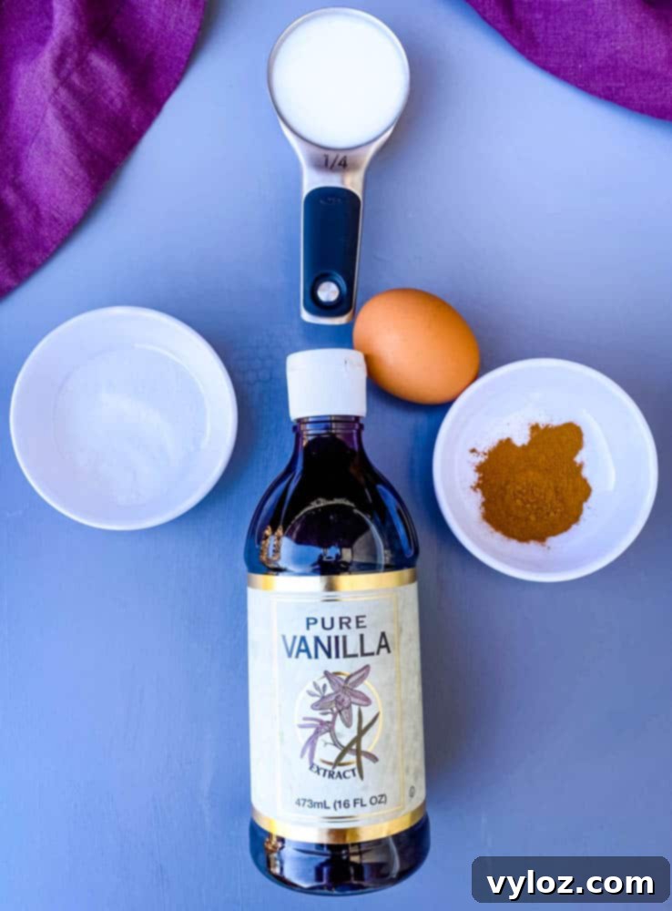 Key ingredients for air fryer French toast sticks: vanilla extract, egg, sweetener, ground cinnamon, and milk in small bowls
