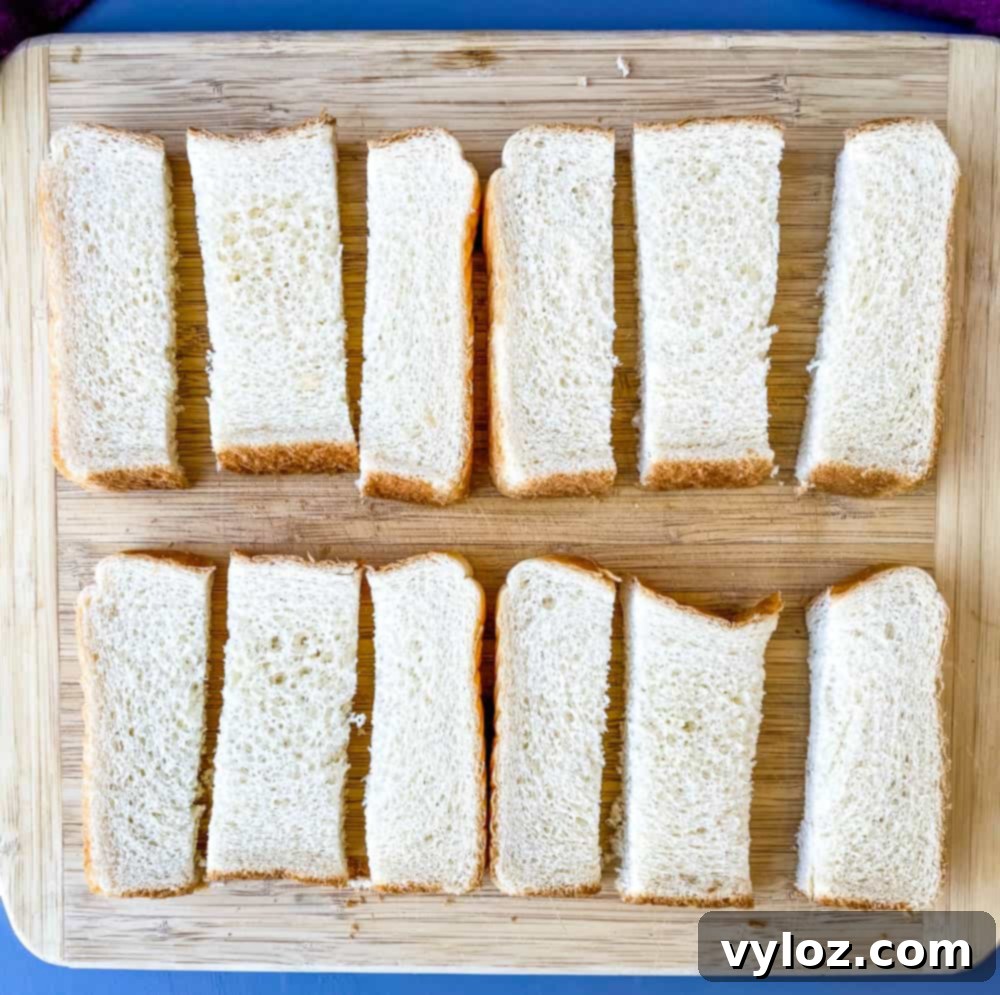 Texas toast bread expertly sliced into uniform sticks, positioned on a wooden cutting board, ready for the next step of dipping into batter