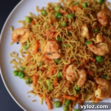 Curry fried rice with shrimp served on a white plate, ready to eat.