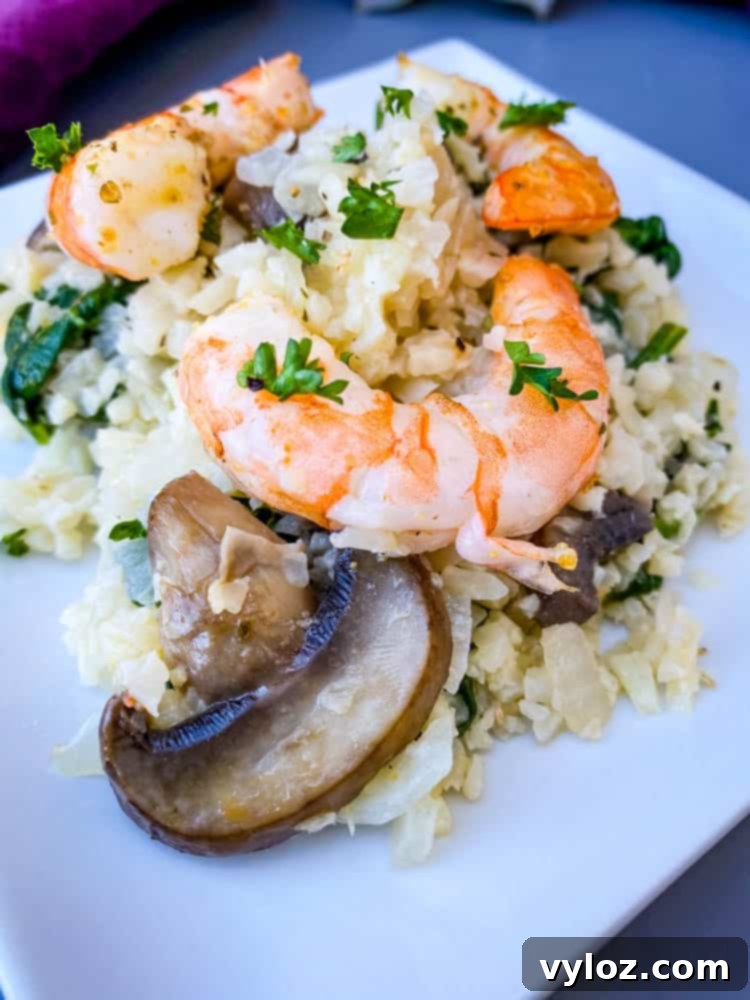 keto low carb cauliflower risotto on a white plate with lemon and shrimp