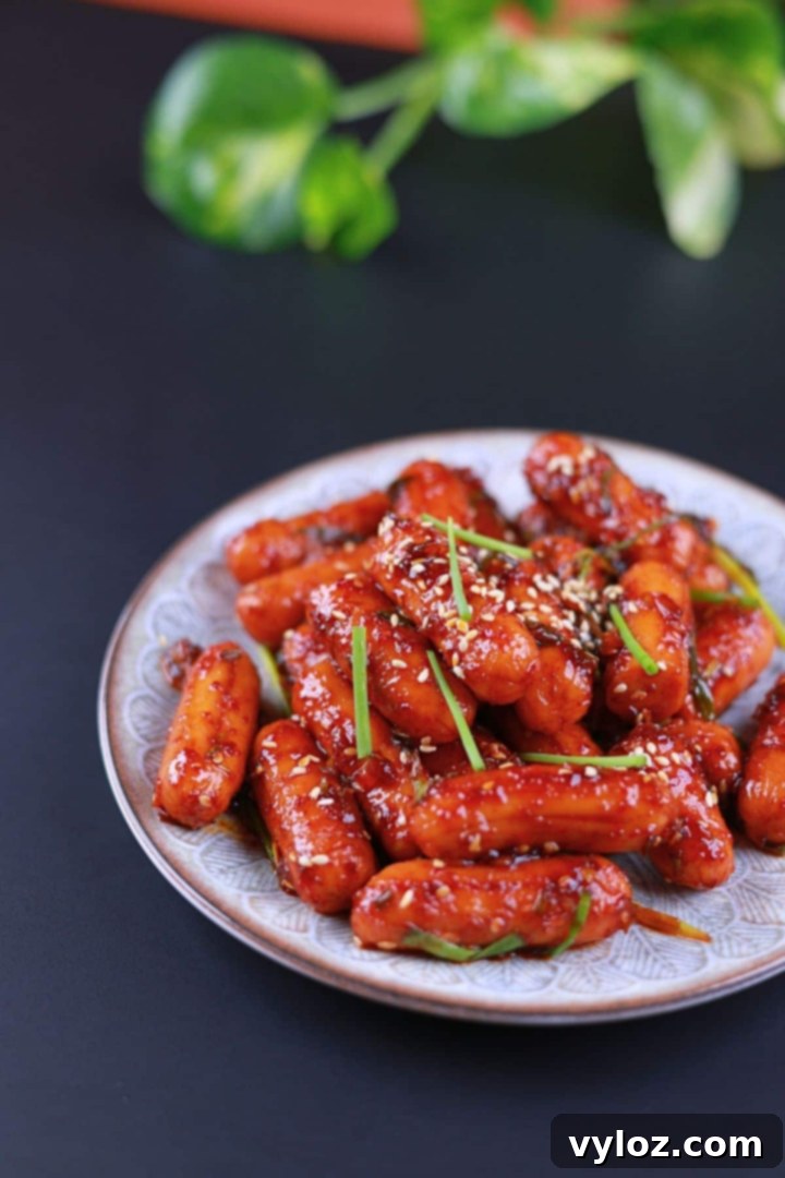 Side view of chicken sausage stir fry coated in a glossy, sweet and spicy sauce.