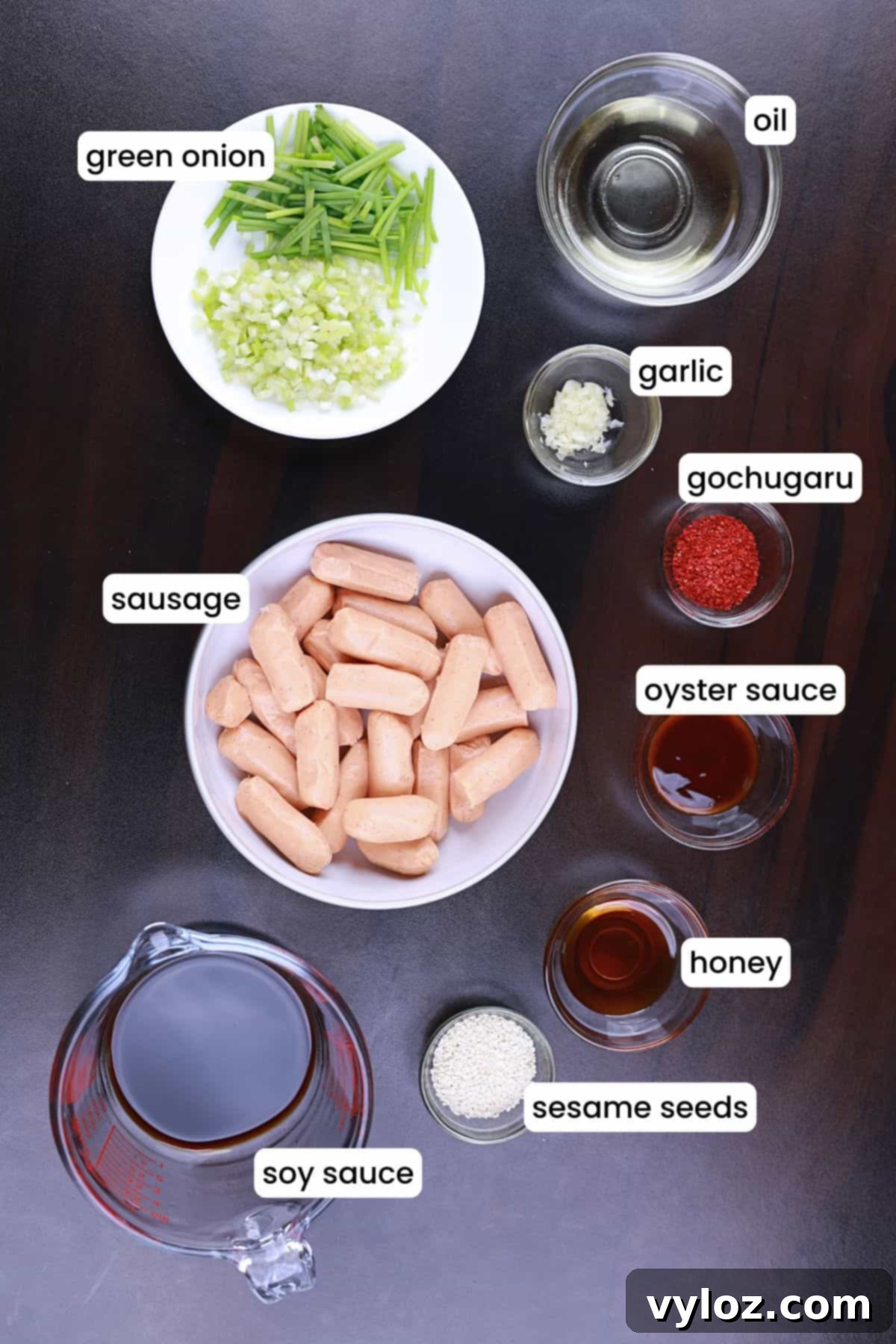 Ingredients for spicy chicken sausage stir fry laid out on a black surface.