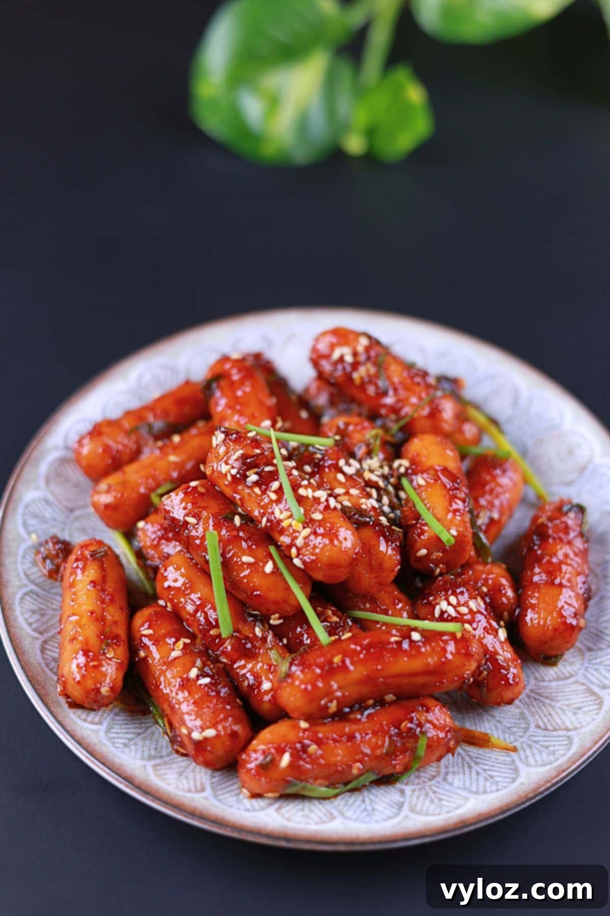 Front view of sweet and spicy sausage stir-fry served on a white plate.