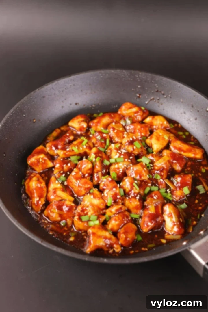 Chinese chicken in a black pan with savory garlic sauce.