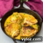 smothered pork chop thighs in a cast iron skillet with gravy